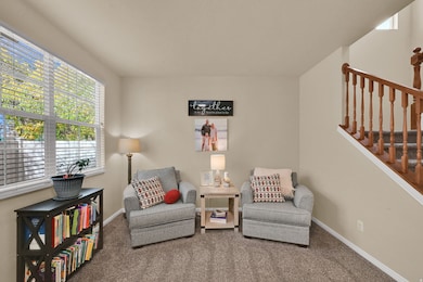 Sitting room featuring carpet flooring and stairs