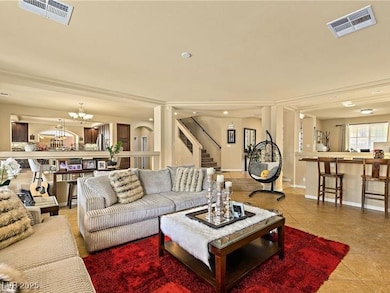 Living room featuring tile patterned flooring, a chandelier, and stairway