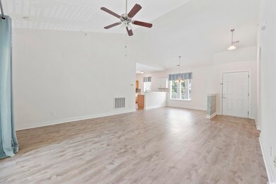 Unfurnished living room featuring high vaulted cei
