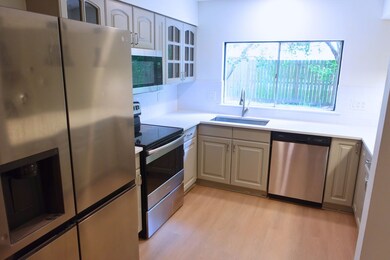 Bright kitchen with stainless appliances and large