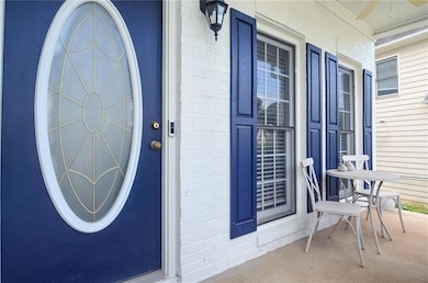 View of exterior entry with covered porch and bric