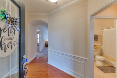 Inviting entry Foyer with hardwood, crown molding, and wainscoting.