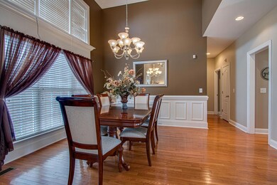 Formal Dining Area with two story ceiling, palladian window and wainscoting