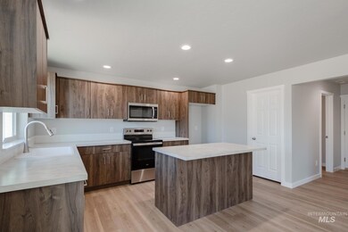 Kitchen with a center island, appliances with stainless steel finishes, light wood-style floors, light countertops, and recessed lighting