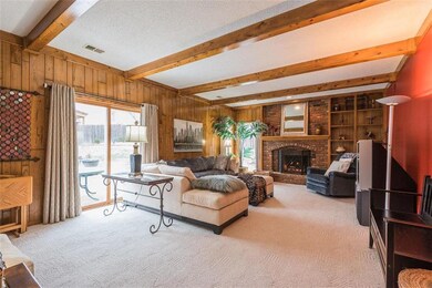 Family room with gas fireplace, wood paneling, acc
