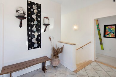 Welcoming foyer with a peeking view of the entrance to the primary suite
