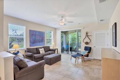 Spacious living room looks out to the lanai and into the conservation area behind the home. Natural beauty at your fingertips.