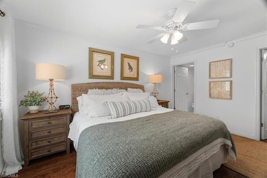 Bedroom with a ceiling fan, baseboards, dark wood-