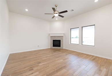 Unfurnished living room featuring a fireplace, recessed lighting, light wood finished floors, and a ceiling fan