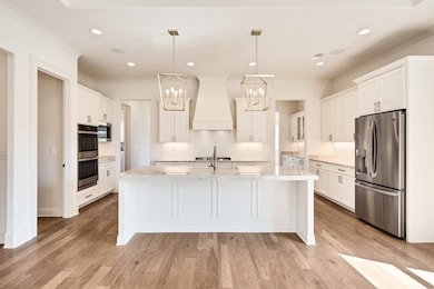 Kitchen featuring custom exhaust hood, appliances 