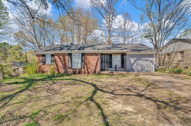 View of front facade with dirt driveway, an attach