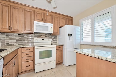 Kitchen with white appliances, light granite counters, 36