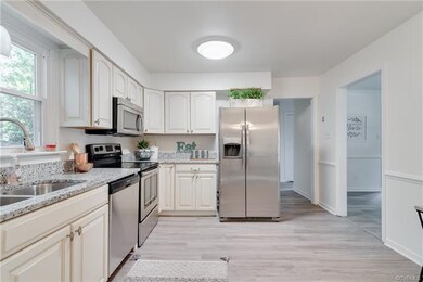 Open kitchen features new appliances and granite c