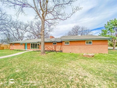 Back of house featuring brick siding, a chimney, a