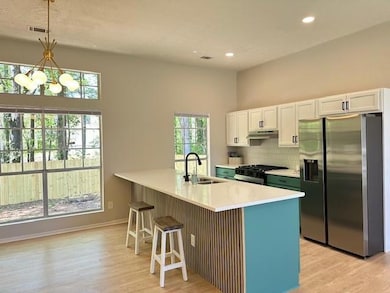 Kitchen featuring range, stainless steel fridge wi