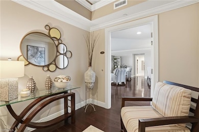 Living area featuring dark wood-type flooring and ornamental molding