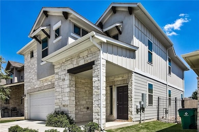 View of front of home featuring stone siding, a g