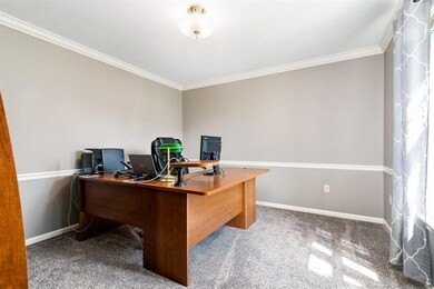Main floor den with a chair rail and crown molding