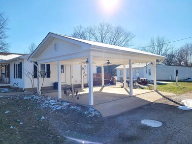 View of parking with a carport, gravel driveway, a