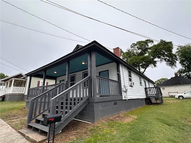 View of property exterior featuring crawl space, a yard, a chimney, and a porch