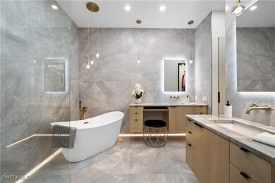 Bathroom with a bath, tile walls, and vanity