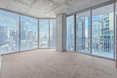 Unfurnished room featuring a wall of windows, a view of skyline, and carpet floors