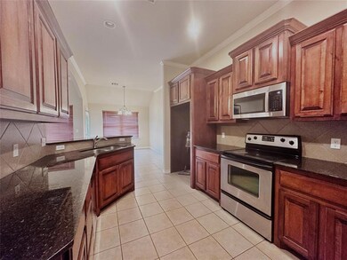 Kitchen featuring tasteful backsplash, dark stone 