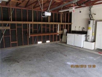 Laundry area in garage; garage is oversoze with shelf over cars for extra storage