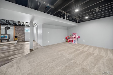 Game room with a wood stove and carpet flooring