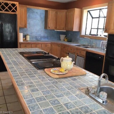 Kitchen island with bar sink and cook top (needs replacing).
