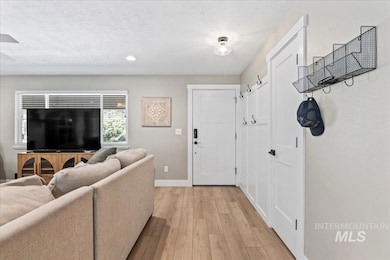 Living area featuring light wood-style flooring, recessed lighting, and a textured ceiling