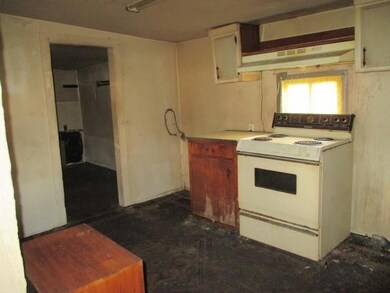 Kitchen featuring white range with electric stovetop, under cabinet range hood, and light countertops