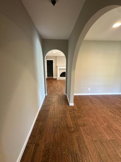 Hallway featuring dark wood-style floors and arch