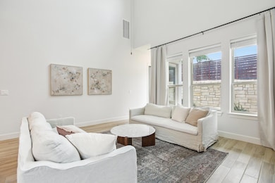 Living room featuring baseboards, a towering ceil