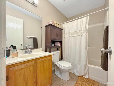 Bathroom with toilet, vanity, tile patterned floors, and shower / tub combo with curtain