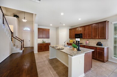 The front entry also features a high ceiling and half bathroom.  The hardwood flooring extends from the front entry, past the kitchen and through the family room.