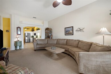 Carpeted living room featuring ceiling fan