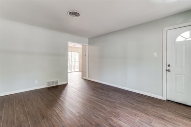 Foyer with dark wood-style flooring and baseboards