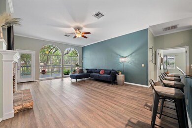 Living area featuring a ceiling fan, wood finishe