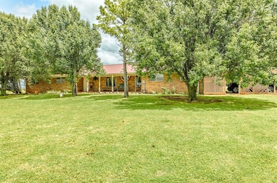 View of grassy yard with covered porch