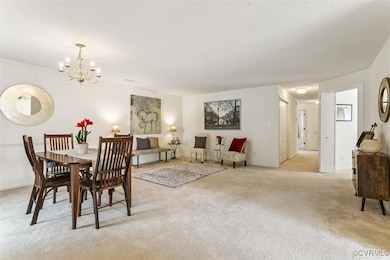 Dining space with light carpet, a chandelier, and