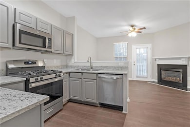 Kitchen with gray cabinets, light stone counters, 