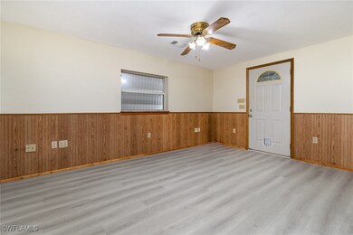 Spare room with ceiling fan, wooden walls, and lig
