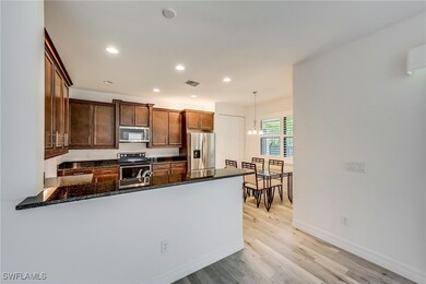 Kitchen featuring a peninsula, appliances with stainless steel finishes, dark stone countertops, recessed lighting, and light wood-type flooring