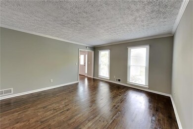 Unfurnished room featuring a chandelier, dark wood