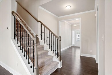 Foyer with an inviting chandelier, crown molding, 