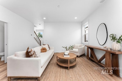 Living area with light wood-style flooring, stairs, and recessed lighting
