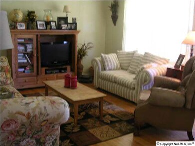 Living room featuring hardwood floors and ceiling fan