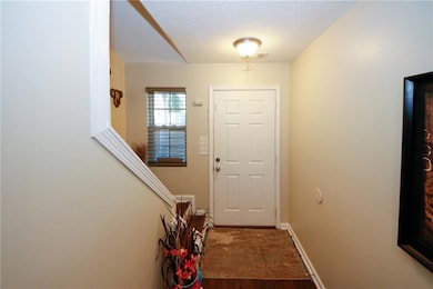 Doorway featuring a textured ceiling and hardwood 