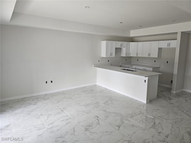 Kitchen with sink, kitchen peninsula, and white ca